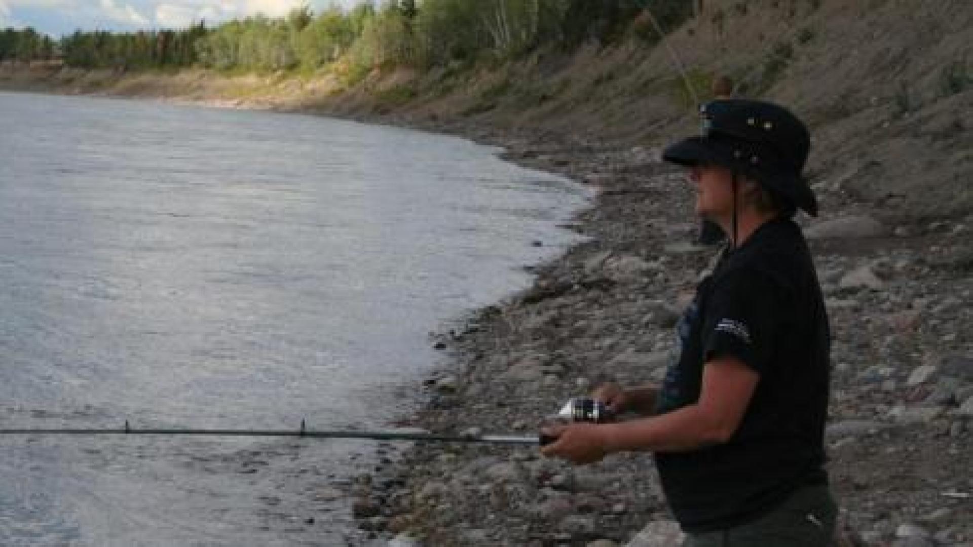 Person on the shore with a fishing rod
